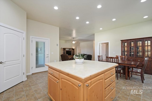 kitchen with ceiling fan, light brown cabinets, and a kitchen island