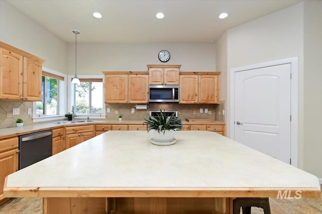 kitchen featuring appliances with stainless steel finishes, a kitchen island, a breakfast bar area, and sink