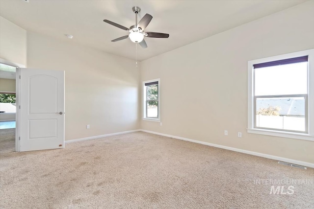 spare room featuring ceiling fan, carpet floors, and a wealth of natural light