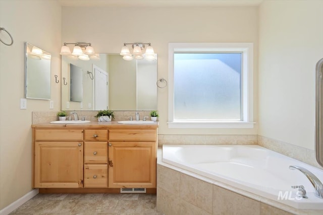 bathroom with vanity and tiled bath