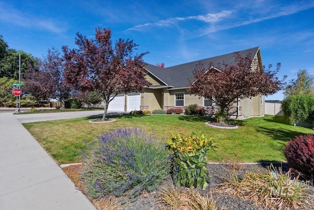 view of property hidden behind natural elements featuring a front yard and a garage