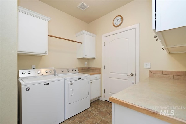 washroom featuring cabinets and washer and clothes dryer