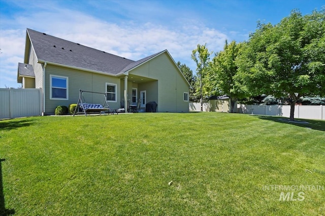 rear view of house featuring a lawn