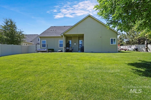 rear view of property with a lawn