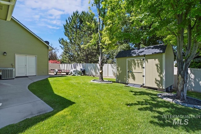 view of yard with central AC unit, a patio area, and a shed