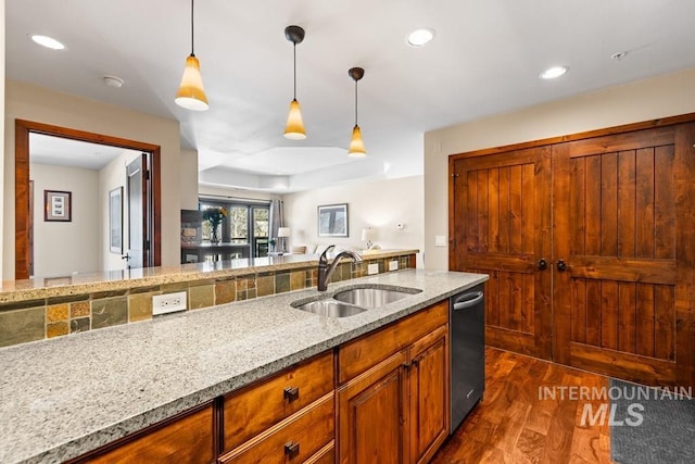 kitchen featuring a sink, stainless steel dishwasher, dark wood-style floors, hanging light fixtures, and recessed lighting