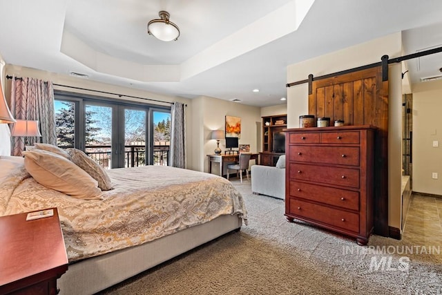 bedroom featuring access to outside, a barn door, a raised ceiling, carpet floors, and an office area