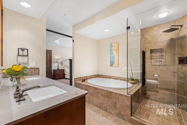 ensuite bathroom with a bath, a stall shower, and double vanity