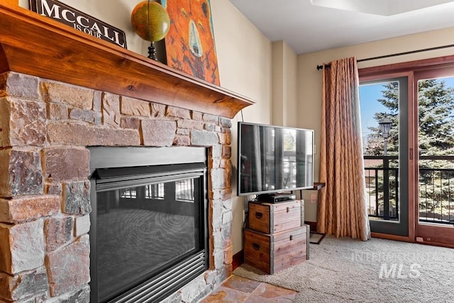 living room featuring healthy amount of natural light, a fireplace, and carpet flooring