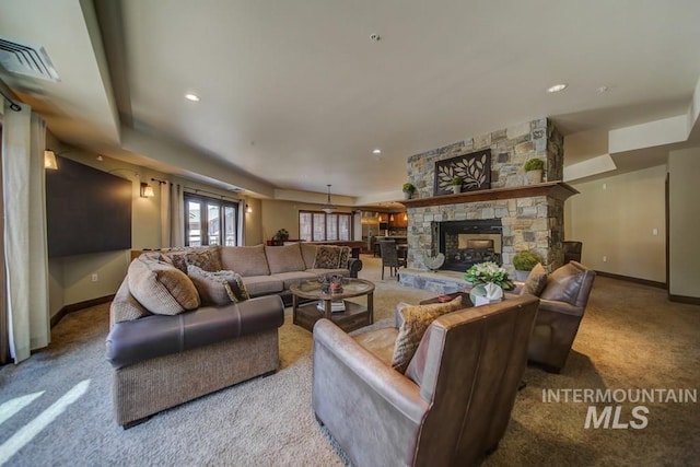 carpeted living room with baseboards, a fireplace, and a raised ceiling