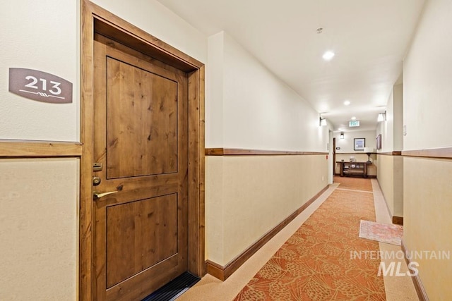 corridor featuring light carpet and baseboards