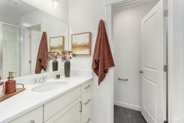 bathroom featuring a shower with shower door and vanity