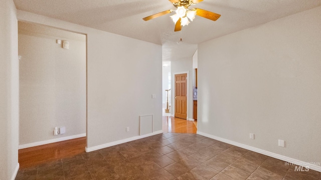 unfurnished room featuring visible vents, ceiling fan, and baseboards