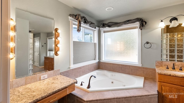 full bathroom featuring a whirlpool tub and vanity