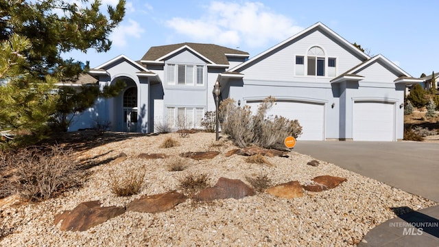 traditional-style home with a garage, driveway, and stucco siding