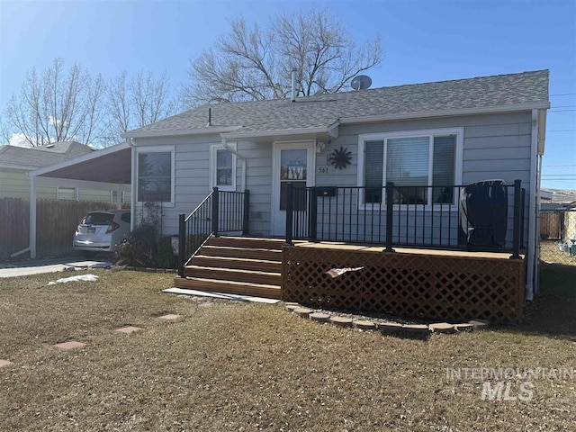 exterior space with a shingled roof and fence