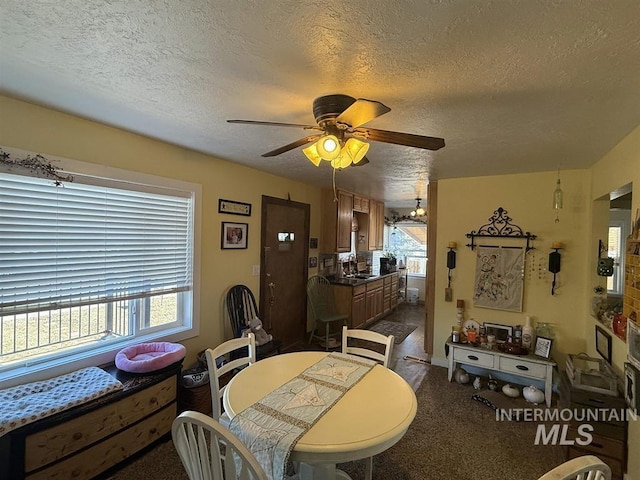 dining area with a ceiling fan and a textured ceiling