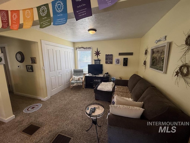 living room with visible vents, carpet flooring, a textured ceiling, and baseboards