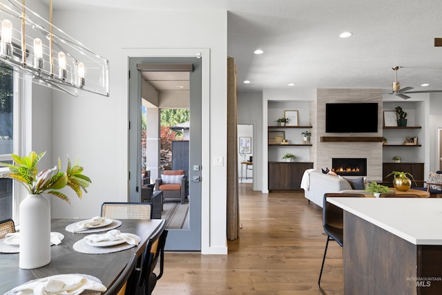 4213 E Divide Pass St, Meridian, ID 83642 - dining area with wood finished floors, a ceiling fan, recessed lighting, and a large fireplace