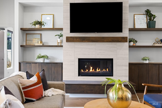 4213 E Divide Pass St, Meridian, ID 83642 - living room featuring wood finished floors, a tile fireplace, and built in features