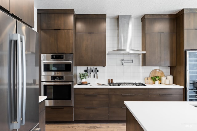 4213 E Divide Pass St, Meridian, ID 83642 - kitchen featuring appliances with stainless steel finishes, wall chimney exhaust hood, modern cabinets, and a textured ceiling