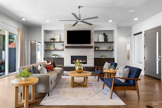 4213 E Divide Pass St, Meridian, ID 83642 - living room featuring a textured ceiling, wood finished floors, built in features, a ceiling fan, and recessed lighting