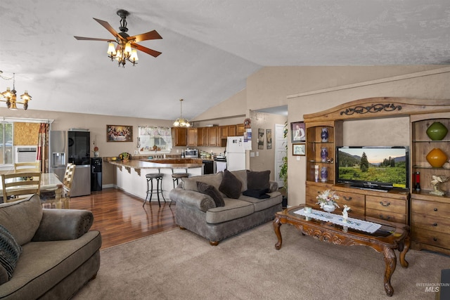 642 Oak St, Twin Falls, ID 83301 - carpeted living room featuring a chandelier, lofted ceiling, ceiling fan, and wood finished floors