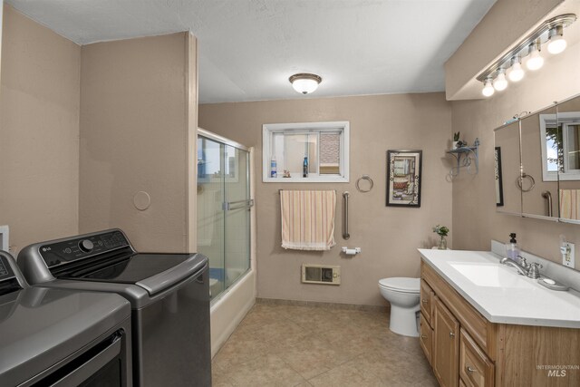 642 Oak St, Twin Falls, ID 83301 - full bath featuring washer and clothes dryer, vanity, toilet, combined bath / shower with glass door, and baseboards