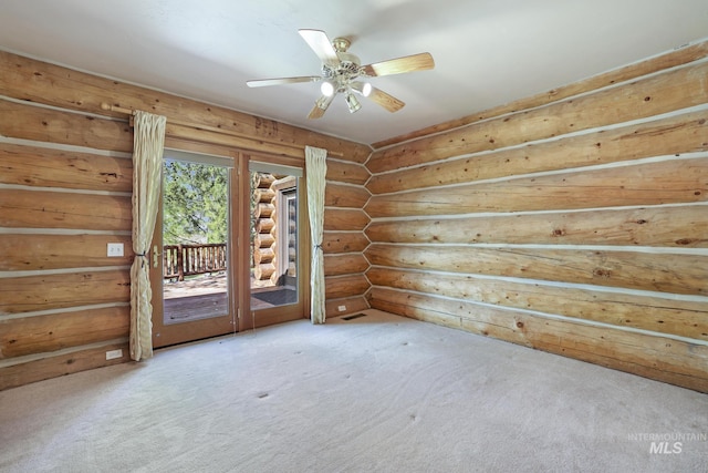 empty room with carpet floors, ceiling fan, and log walls