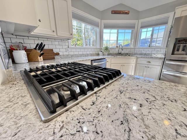 kitchen featuring white cabinetry, appliances with stainless steel finishes, a sink, and tasteful backsplash