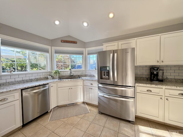 kitchen featuring a sink, appliances with stainless steel finishes, decorative backsplash, and white cabinets