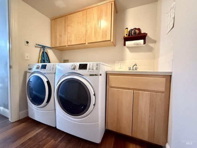 laundry area featuring baseboards, dark wood-style flooring, cabinet space, and washing machine and clothes dryer