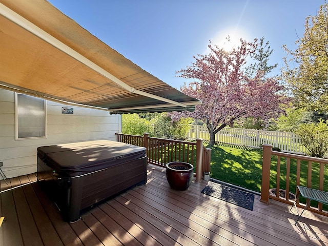 wooden deck with a lawn, a hot tub, and fence