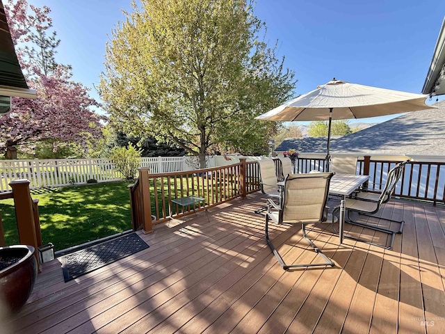wooden terrace featuring a yard, a fenced backyard, and outdoor dining space