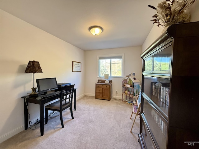 home office with baseboards and light carpet