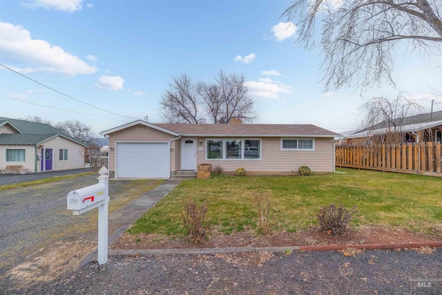 ranch-style home with aphalt driveway, an attached garage, a front yard, and fence