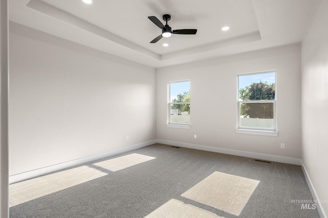 unfurnished room featuring recessed lighting, baseboards, a raised ceiling, and carpet