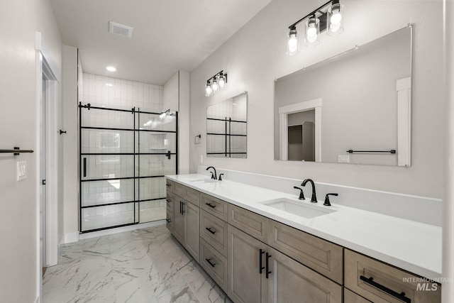 bathroom with visible vents, marble finish floor, tiled shower, and a sink