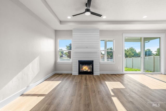 unfurnished living room with wood finished floors, baseboards, a fireplace, recessed lighting, and ceiling fan