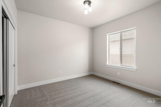 unfurnished room featuring visible vents, baseboards, and carpet floors