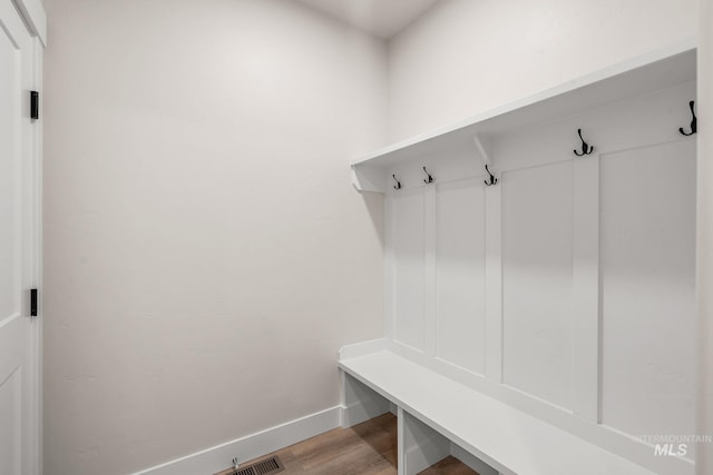 mudroom featuring visible vents, baseboards, and wood finished floors