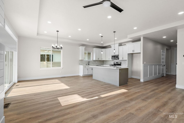 kitchen with visible vents, open floor plan, appliances with stainless steel finishes, white cabinets, and a sink