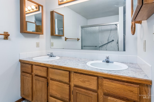 full bathroom with double vanity, a stall shower, and a sink