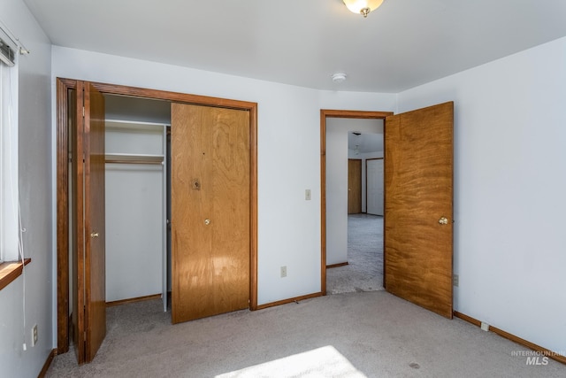 unfurnished bedroom featuring a closet, baseboards, and carpet