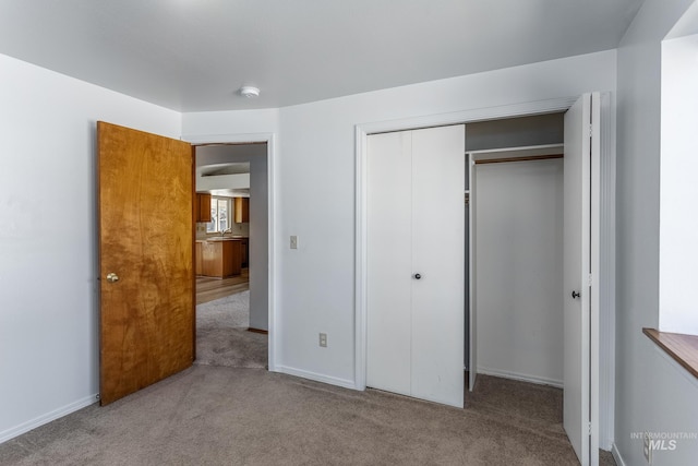 unfurnished bedroom with a closet, baseboards, and carpet flooring