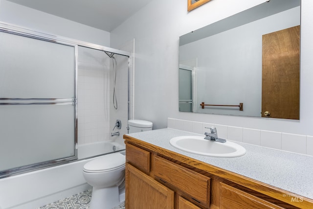 full bathroom with combined bath / shower with glass door, toilet, and vanity