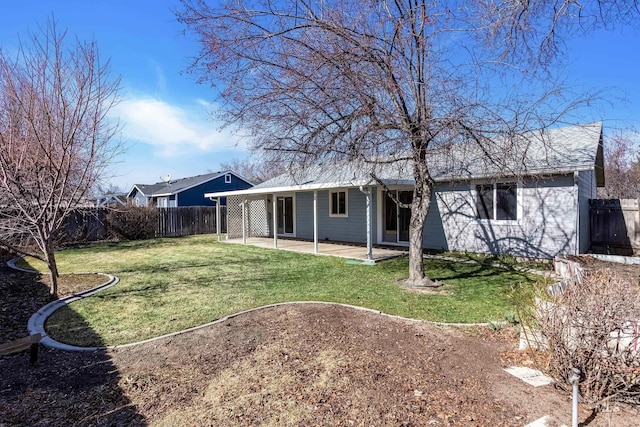 rear view of house with a lawn, a patio, and a fenced backyard