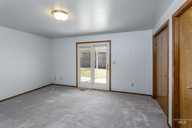 empty room featuring visible vents, baseboards, and carpet flooring