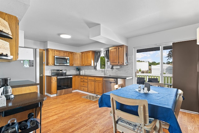 3404 Chukar Ln, Clarkston, WA 99403 - kitchen with stainless steel appliances, light wood-style floors, brown cabinets, and tasteful backsplash