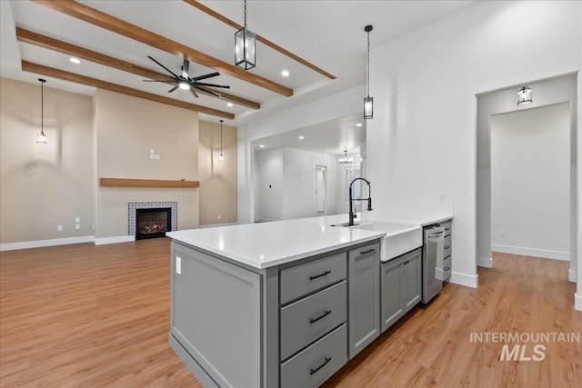 kitchen with gray cabinets, sink, stainless steel dishwasher, and decorative light fixtures